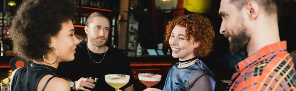 Веселые многонациональные друзья, держащие коктейли, проводя время в баре, баннере — стоковое фото