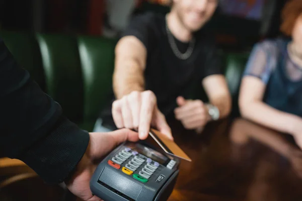 Verschwommene Ansicht eines Mannes, der in Bar mit Kreditkarte bezahlt — Stockfoto