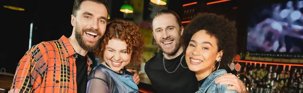Gente alegre multiétnica mirando a la cámara mientras pasa tiempo en el bar, pancarta - foto de stock