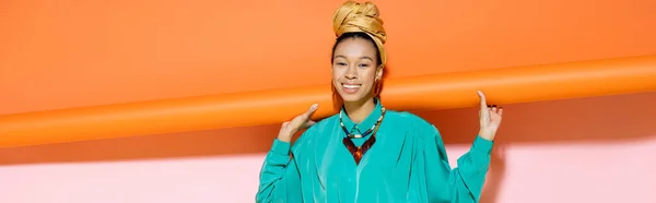 Femme afro-américaine joyeuse avec foulard posant sur fond coloré, bannière — Photo de stock