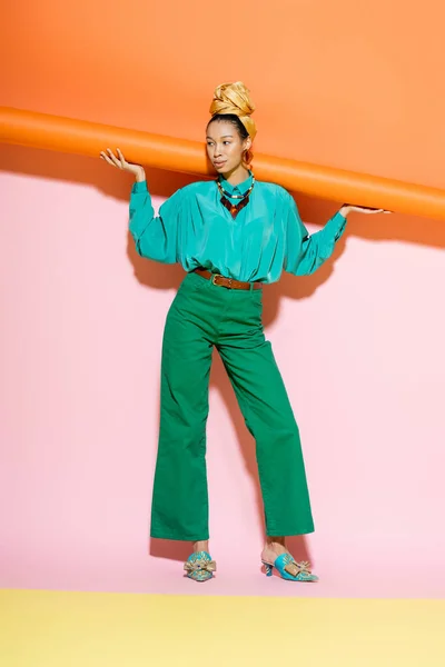Lunghezza completa della donna afroamericana alla moda in abito estivo in posa su sfondo colorato — Foto stock
