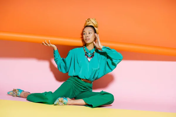 Donna afro-americana alla moda in velo e vestito luminoso volto toccante su sfondo colorato — Foto stock
