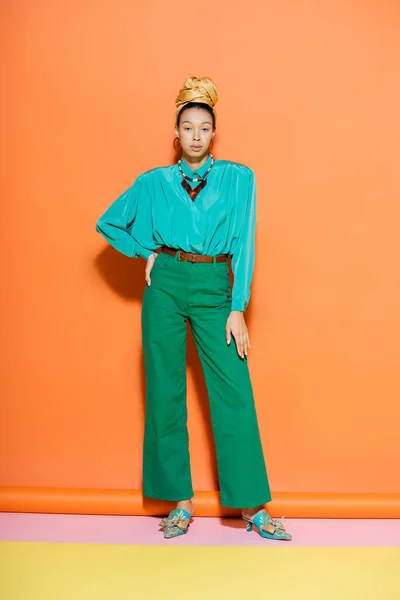 Longitud completa de la mujer afroamericana de moda en traje de verano posando sobre fondo naranja - foto de stock