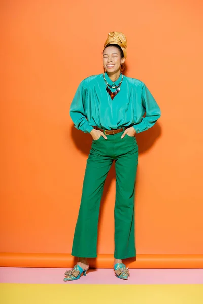 Longitud completa de alegre modelo afroamericano en traje de verano posando sobre fondo colorido - foto de stock