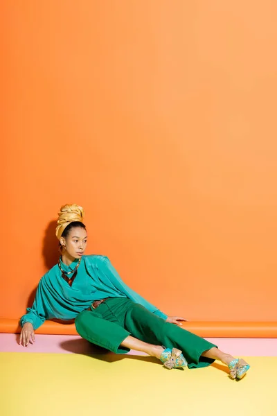Модная африканская американская модель в летней одежде позирует на красочном фоне — стоковое фото