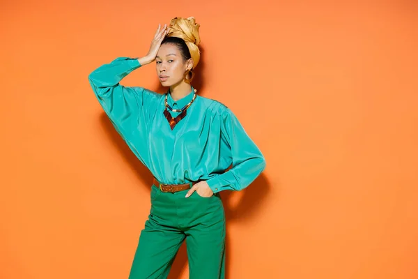 Junge Afroamerikanerin im Sommer-Outfit blickt in die Kamera auf orangefarbenem Hintergrund — Stockfoto