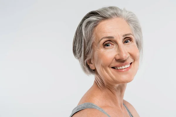 Porträt einer zufriedenen Seniorin mit grauen Haaren, die vereinzelt in die Kamera blickt — Stockfoto