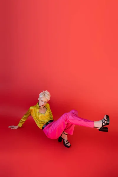In voller Länge Albino-Frau in Sandalen und trendigem Outfit posiert auf karminrosa — Stockfoto
