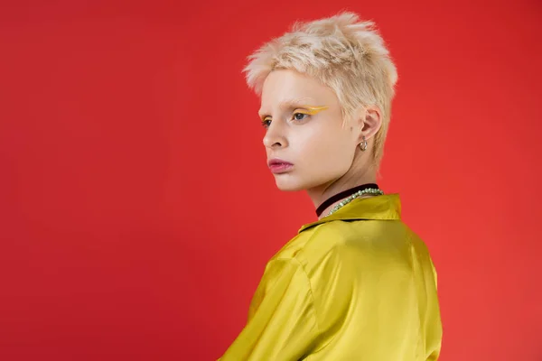 Porträt einer blonden Albino-Frau mit hellem Eyeliner auf karminrosa Hintergrund — Stockfoto