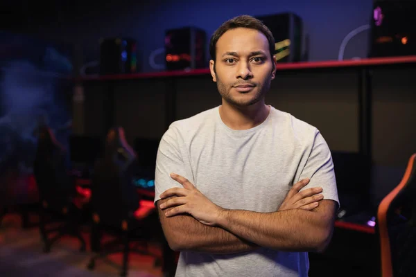 Indian man crossing arms and looking at camera in cyber club — Stock Photo