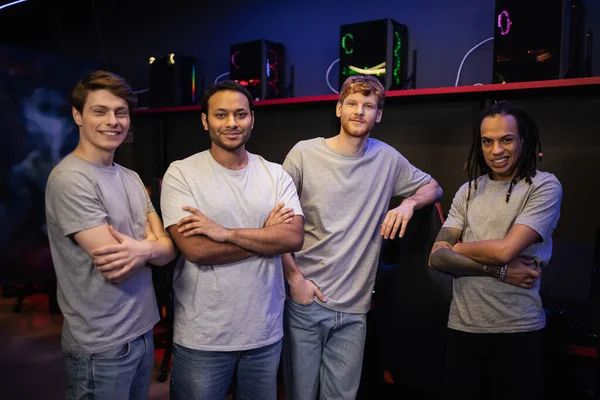 Positive multiethnic team of gamers looking at camera in cyber club — Stock Photo