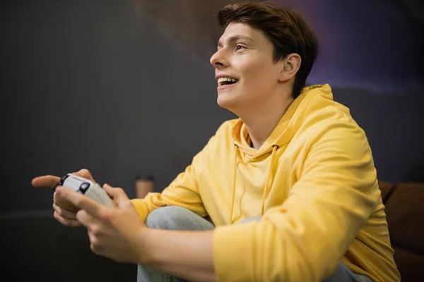 KYIV, UKRAINE - FEBRUARY 13, 2023: Cheerful young man playing video game in cyber club — Stock Photo