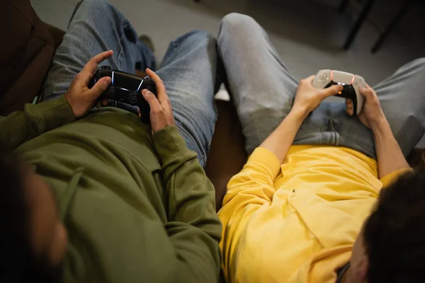 KYIV, UKRAINE - FEBRUARY 13, 2023: Top view of interracial men playing video game in cyber club — стокове фото