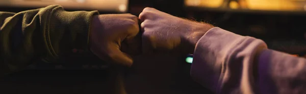 Обрезанный вид друзей, дающих кулак в кибер-клубе, баннер — стоковое фото