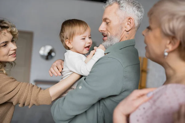 Незадоволена дівчина плаче в руках бородатого дідуся вдома — стокове фото