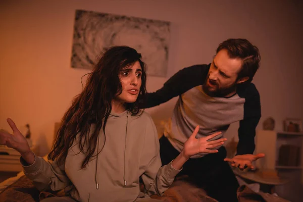 Aggressiver Mann streitet nachts mit Freundin im Bett — Stockfoto