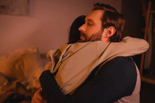Fürsorglicher Mann umarmt und beruhigt Freundin abends zu Hause — Stockfoto