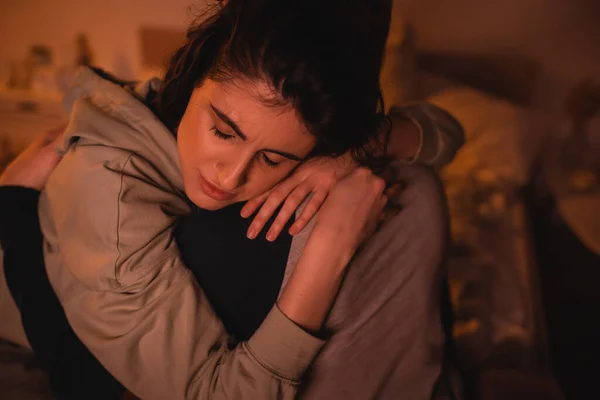 Mujer disgustada abrazando novio en el dormitorio por la noche - foto de stock