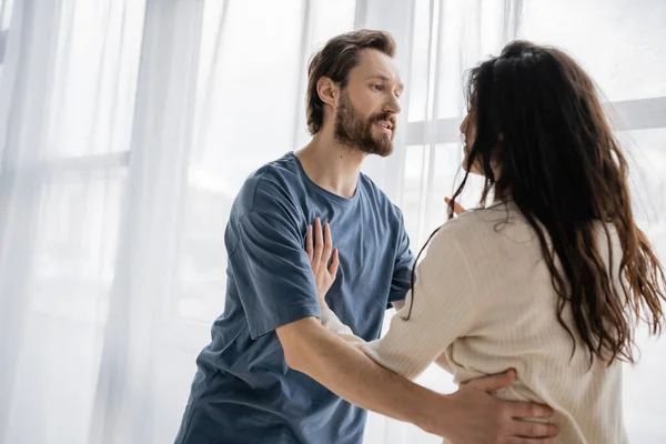 Angry woman pushing boyfriend during quarrel at home — Stock Photo