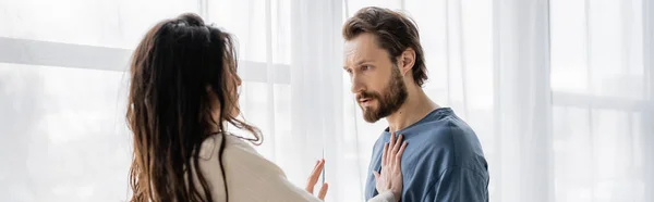 Brunette woman showing no gesture at angry boyfriend during conflict at home, banner — Stock Photo