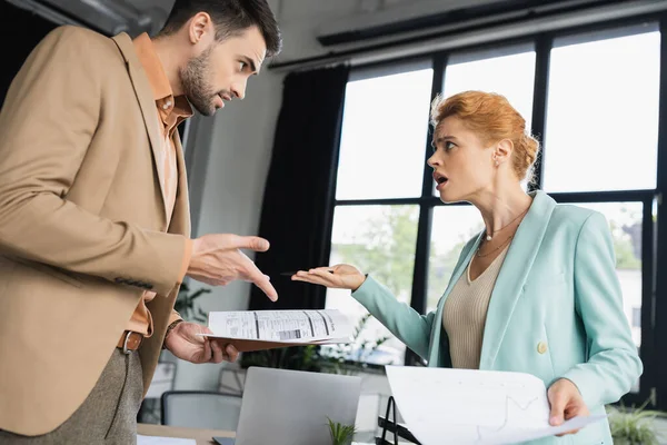 Displeased managers holding documents while gesturing and quarreling in office — Stock Photo