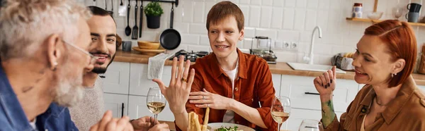 Überglücklicher schwuler Mann zeigt Ehering während Familienessen in Küche, Banner — Stockfoto