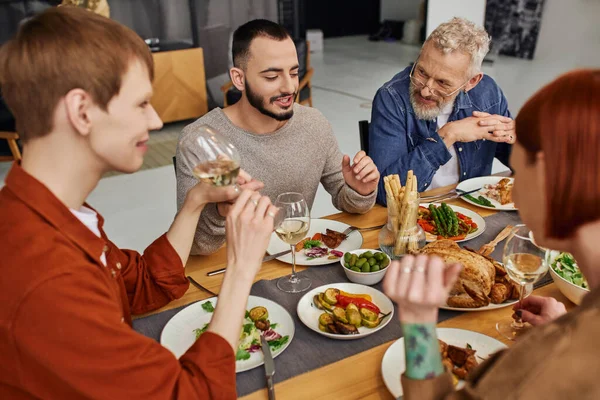 Gai barbu gay homme parler près copain et parents pendant famille souper à la maison — Photo de stock