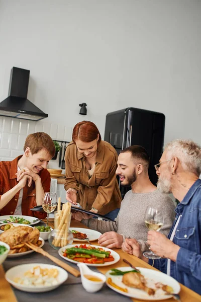 Familie mit Kindern sitzt und lächelt beim gemeinsamen Kochen zu Hause in der Küche am Tisch — Stockfoto