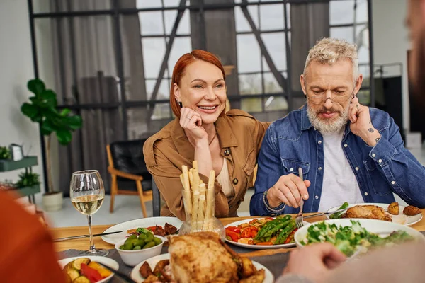 Pais satisfeitos ter jantar de família perto de casal gay em primeiro plano desfocado — Fotografia de Stock