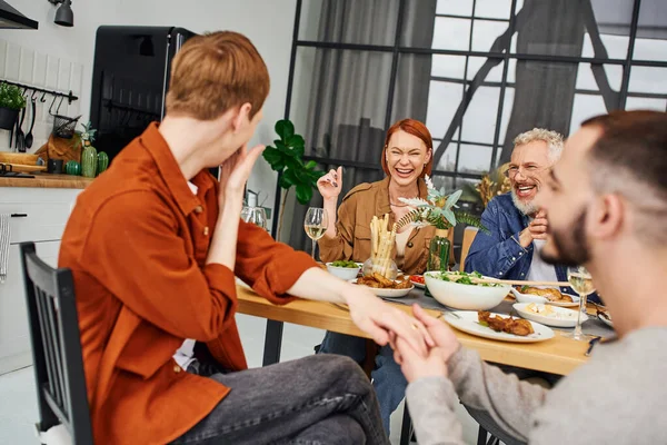 Blurred gay man making marriage proposal to boyfriend during supper with overjoyed parents in modern kitchen — Stock Photo