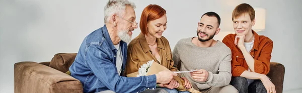 Bearded gay man giving wedding invitation to parents at home, banner — Stock Photo