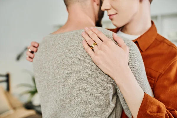 Vista parcial de hombre gay con anillo de boda abrazando novio en casa - foto de stock