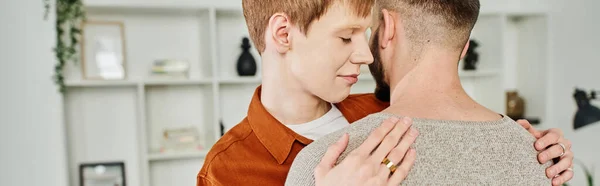Feliz gay hombre en boda anillo abrazando novio en casa, bandera - foto de stock