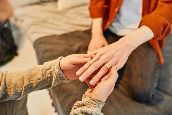 Cropped view of man wearing wedding ring on gay partner while making marriage proposal at home — Stock Photo