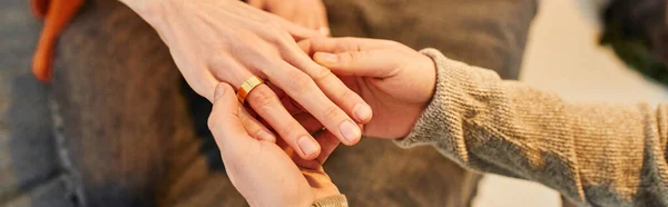 Частичный взгляд человека, носящего обручальное кольцо на гей-партнера при составлении предложения о браке, баннер — стоковое фото