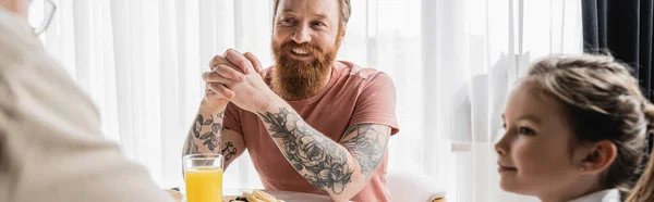 Веселий гей-чоловік сидить біля сніданку і батьки вдома, банер — стокове фото