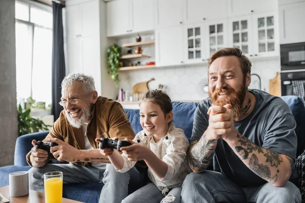 KYIV, UKRAINE - APRIL 19, 2023: Smiling preteen child playing video game with same sex partners at home — Stock Photo