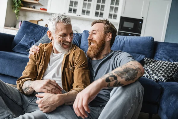 Spensierato gay coppia abbracci e guardando ogni altri a casa — Foto stock