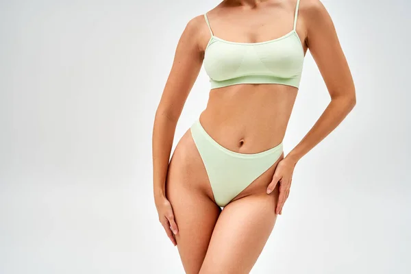 Cropped view of seductive young woman in modern light green panties and bra touching hip and standing isolated on grey, self-acceptance and body positive concept, femininity, body love — Stock Photo