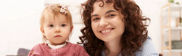 Portrait of happy woman and child, curly working mother hugging baby girl, balanced lifestyle, bonding, family time, modern parenting, engaging with kid, loving motherhood, banner — Stock Photo