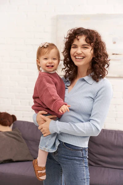 Quality family time, working mother with curly hair holding in arms baby girl, woman and her toddler daughter, modern parenting, work life harmony, bonding and engaging with kid, happiness, laughter — Stock Photo