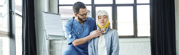 Professionnel de la santé dans les lunettes et uniforme mettre orthèse de cou sur la femme asiatique avec tête pansée, concept de réponse aux situations d'urgence, séminaire de premiers soins, bannière — Photo de stock