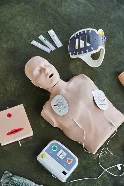 Top view of CPR manikin, automated external defibrillator, wound care simulator, neck brace and syringes, medical equipment for first aid training and skills development — Stock Photo