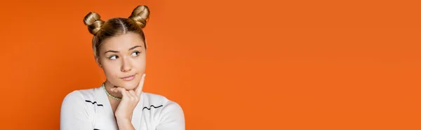 Porträt eines nachdenklichen Teenagers mit Frisur und buntem Make-up, der wegschaut, während er in lässiger Kleidung isoliert auf orangefarbenem, trendigem Teenie-Mädchen posiert, das Individualität ausdrückt, Banner mit Kopierraum — Stockfoto