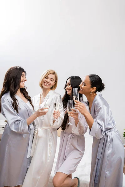 Девичник, многокультурные девушки с бокалами шампанского, празднование перед свадьбой, брюнетка и блондинка, невеста и подружки невесты, различные национальности, азиатские и черные женщины — стоковое фото