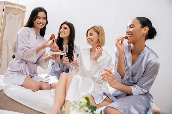 Bridal party, strawberries and champagne, multicultural women, brunette and blonde girlfriends, bride and her bridesmaids spending time together, cultural diversity, asian woman looking at camera — Stock Photo