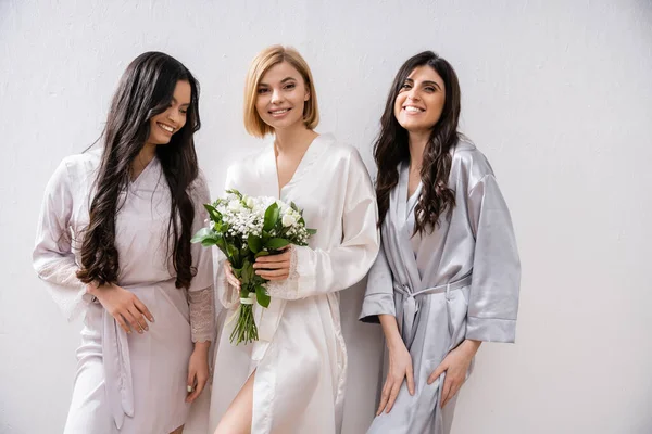 Happy bride with white flowers, cheerful and diverse bridesmaids, bridal bouquet, cultural diversity, friendship goals, brunette and blonde women, bridal shower, smile and joy — Stock Photo