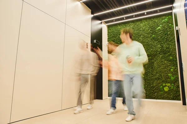 Длительное пребывание предпринимателей, идущих по коридору в коворкинг-офисе с современным интерьером и обсуждающих бизнес-проект, сотрудничество, партнерство и концепцию продуктивности — стоковое фото