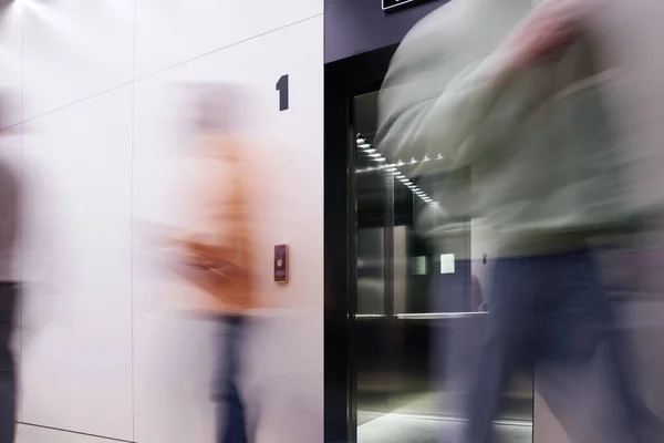 Langzeitbelichtung von Geschäftsleuten in der Nähe von Aufzügen mit offenen Türen in zeitgenössischen Coworking-Büros mit High-Tech-Interieur, Bewegung, dynamischem Geschäft, Produktivität — Stockfoto