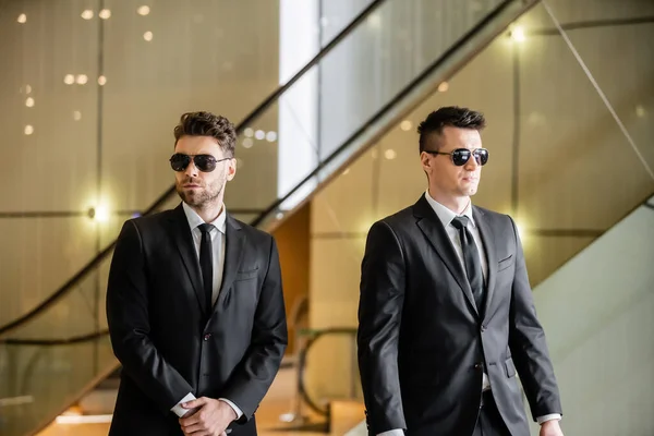 Security measures of luxury hotel, two handsome men in formal wear and sunglasses, bodyguards on duty, safety management, vigilance, suits and ties, private security, strong guards — Stock Photo